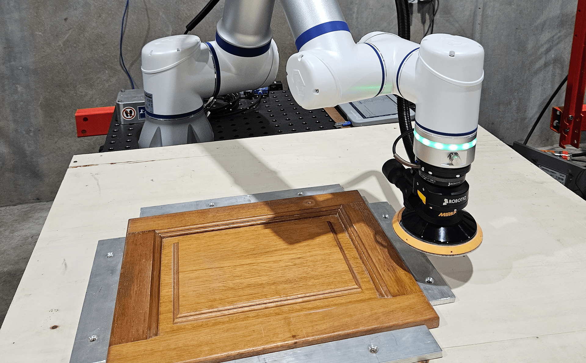 Cobot performing sanding and surface finishing operation on workpiece